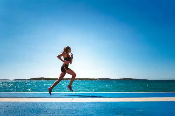 Woman running showing strong leg muscle Bridge End